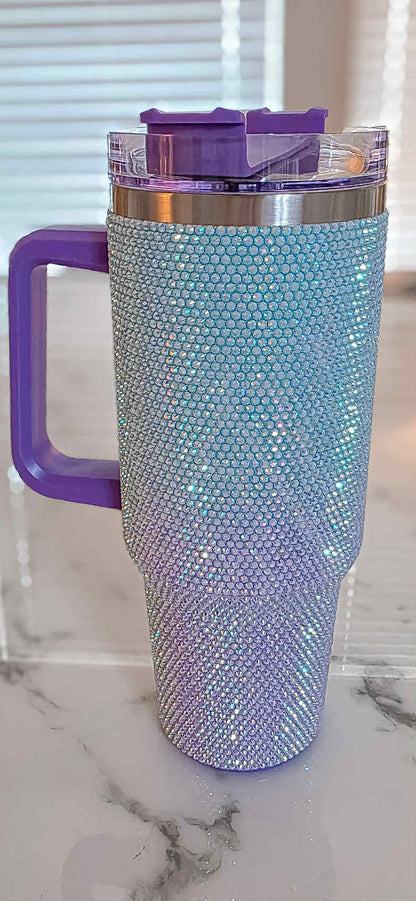 Blinged-out tumbler with purple handle on a marble surface